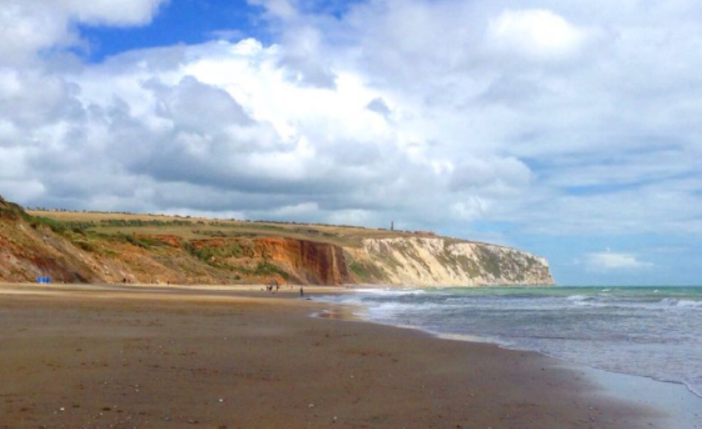 Sandy shoreline at Yaverland Beach with gentle waves lapping the sand.