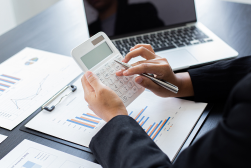 Hands using a calculator with financial reports
