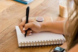 Hand writing notes in a notebook
